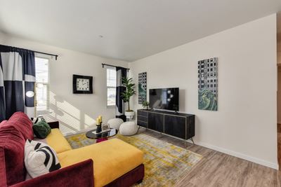 living room with red and yellow couch and Harwood inspired flooring